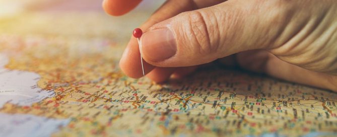 Job relocation: image shows a hand putting a red pin into a location on a map.