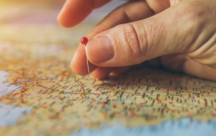 Job relocation: image shows a hand putting a red pin into a location on a map.
